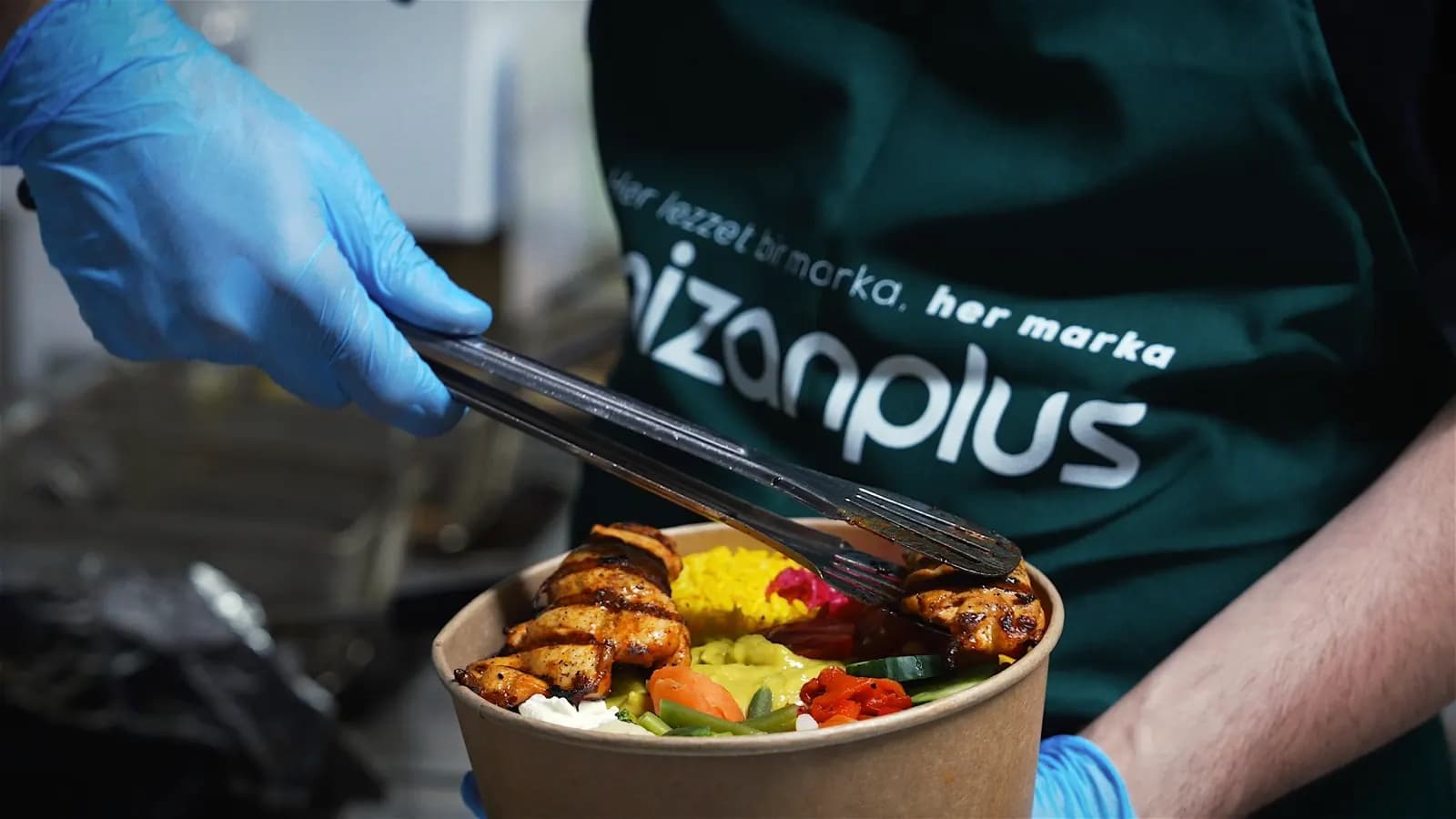 Bowl being portioned by a cook in a Mizanplus apron